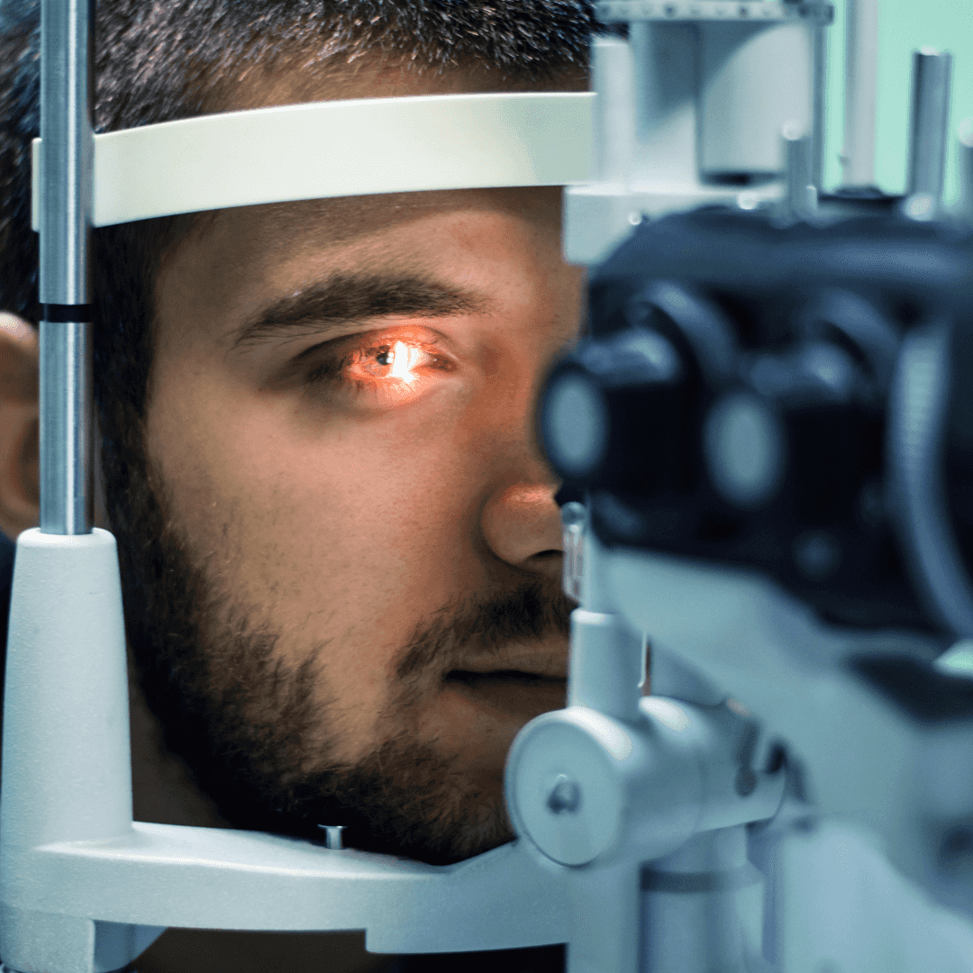 Una persona se está realizando un examen visual por medio de una máquina especializada.